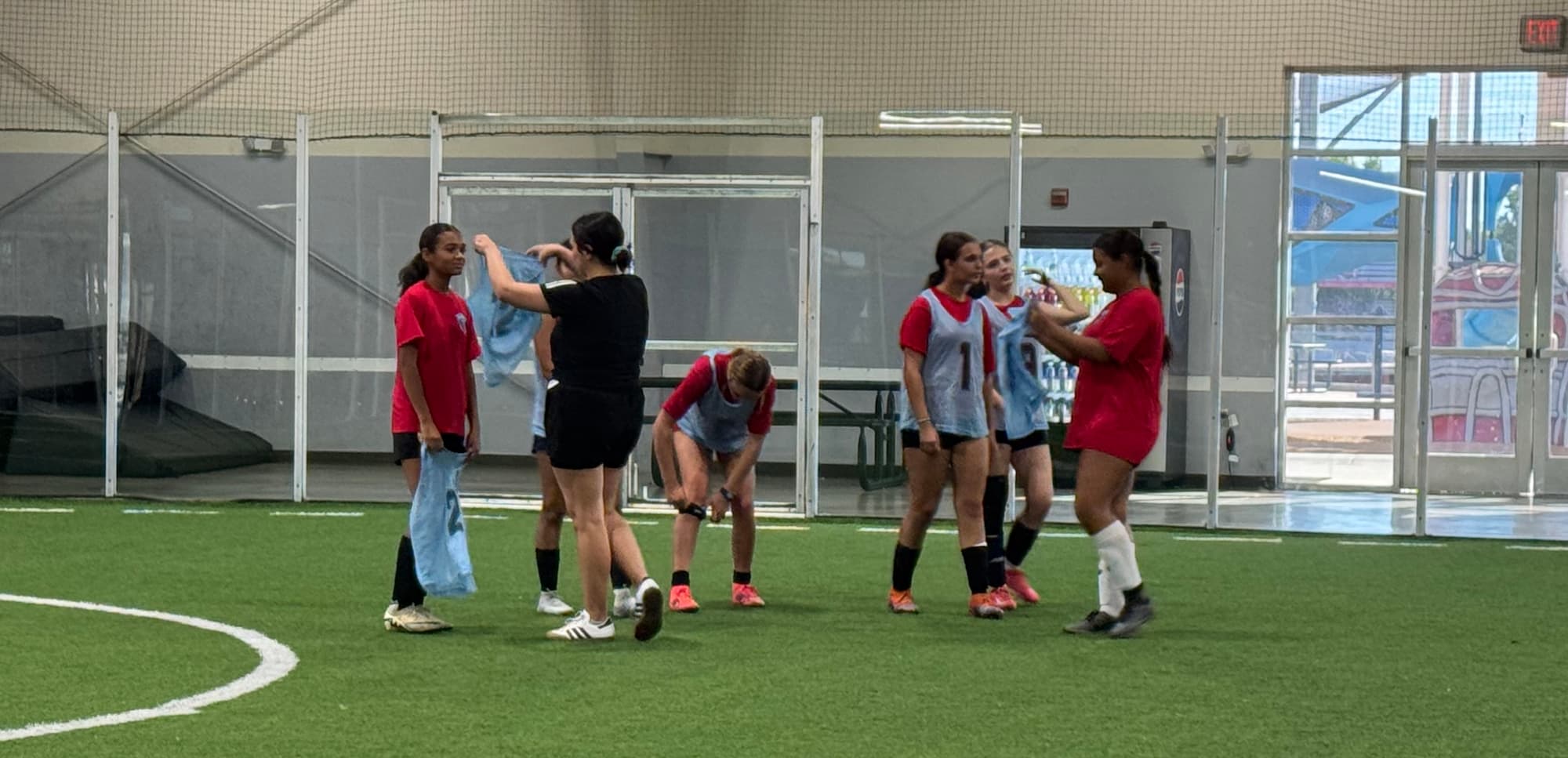 a group putting on training pennies in an indoor soccer facility